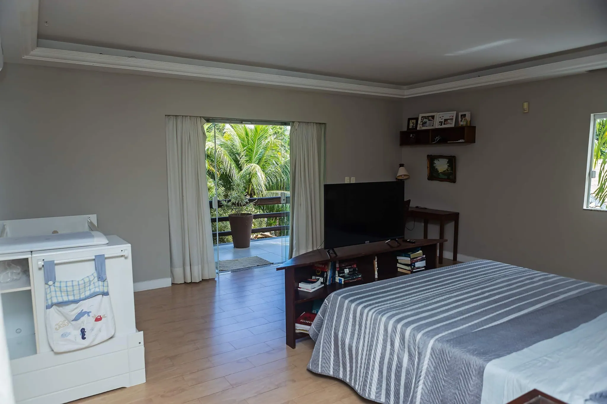 Suíte master ampla com cama king, ar-condicionado e porta para a varanda